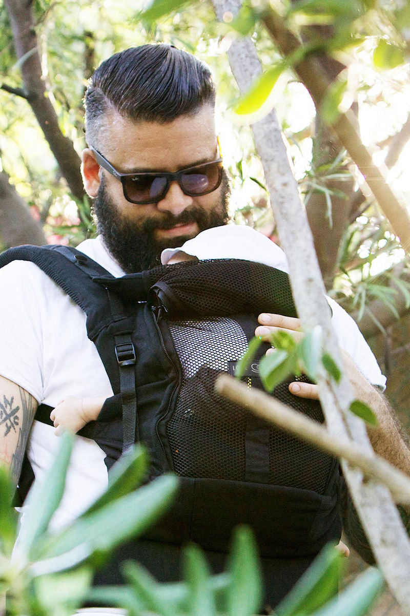 Dad is babywearing his baby outside in the PhysioCarrier, babycarrier Love Radius