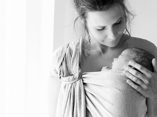 baby in mom's arms, skin to skin in a sling